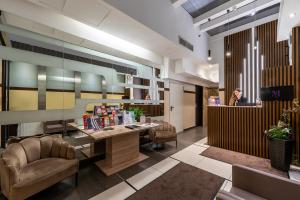 a lobby with a table and chairs and a person at Promenade Hotel by Mellow Mood Hotels in Budapest