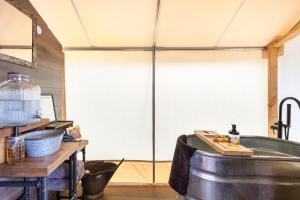 une cuisine avec une baignoire et une grande fenêtre dans l'établissement Tombstone's Historic Glamping Escape, à Tombstone 13 autres photos