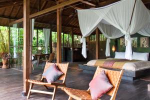 En eller flere senge i et værelse på Villa Mahadevi 2 Ubud Jungle Retreat Joglo