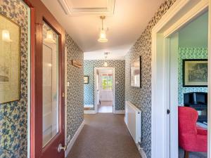 einen Flur mit blau und weiß gefliesten Wänden in der Unterkunft Dairy Cottage in Aylesbury