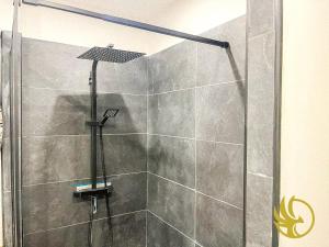 a shower with a glass door in a bathroom at Le grenier des hortillonnages in Camon