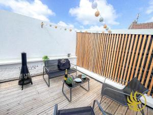 a balcony with a table and chairs on a roof at Le grenier des hortillonnages in Camon