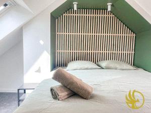 a bedroom with a large bed with a wooden headboard at Le grenier des hortillonnages in Camon