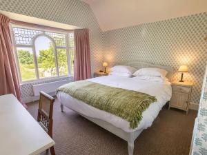 ein Schlafzimmer mit großem Bett und Fenster in der Unterkunft Dairy Cottage in Aylesbury