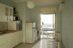 a kitchen with a refrigerator and a table with a view of the ocean at La voce del mare in Agropoli