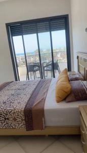 a bed in a room with a large window at البحر والشمس والطبيعه in Pont Blondin