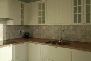 a kitchen with white cabinets and a sink at La voce del mare in Agropoli +30 photos