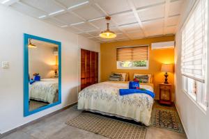 a bedroom with two beds and a mirror at Aruba Casita in Noord