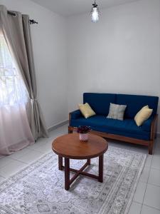 un salon avec un canapé bleu et une table dans l'établissement Cozy Buxton, à Mombasa