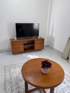 un salon avec une table et une télévision dans l'établissement Cozy Buxton, à Mombasa