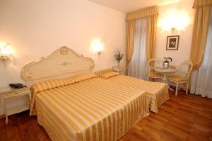 a hotel room with two beds and a lamp at Casa Sul Molo in Venice