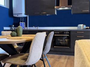 a kitchen with a table with chairs and a blue wall at Corporate Comforts Nordwalde in Nordwalde