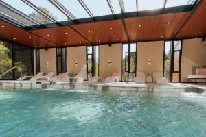 a large swimming pool with chairs and a swimming pool at La Urumpta Hotel, AKEN MIND in Río Cuarto