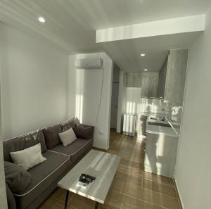 a living room with a couch and a kitchen at Megi's apartment in Shëngjin