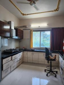a kitchen with a desk and a chair in it at dwarika home stay ujjain in Ujjain