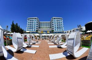 a group of white chairs in front of a building at Azura Deluxe Resort & Spa - Ultra All Inclusive in Avsallar
