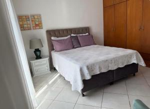a bedroom with a bed with purple pillows at Casa Klippel in Petrópolis