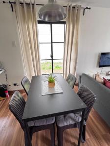 una mesa negra y sillas en la sala de estar. en Cozy Scandi Industrial House, en San Pablo