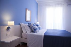 a blue bedroom with a bed and a window at B&B L'Artista in Portopalo