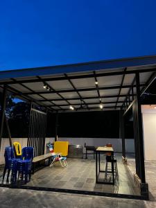 a patio with chairs and tables and a blue ceiling at The Rina Homestay-Whole Villa with Private Pool,BBQ & Karaoke-1Min Beach- in Port Dickson +46 photos