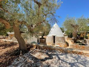 莫诺波利Dimora&Pool Gerardo的前方有树的石头建筑