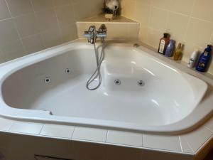 a large white bath tub with a faucet in a bathroom at La Villa des Vennes in Heure +18 photos