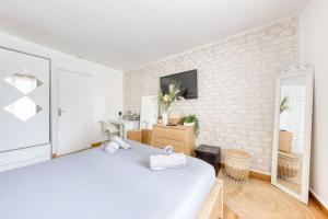 Dormitorio blanco con pared de ladrillo blanco en Escapade à Versailles - 3 min de Versailles Chantiers, en Versalles 18 fotos más