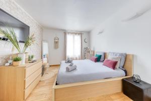 Un dormitorio con una cama y un televisor de pantalla plana. en Escapade à Versailles - 3 min de Versailles Chantiers, en Versalles