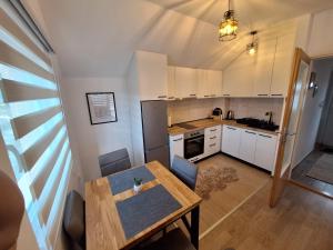 a kitchen with a wooden table and a dining room at Apartman Kops Lukavica, Istočno Sarajevo in Vranješ