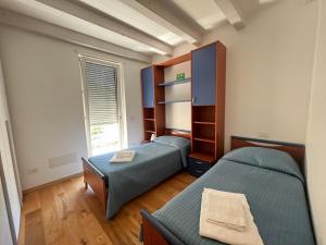a bedroom with two beds and a window in it at Appartamento Margherita Residenza Prealba in Levanto