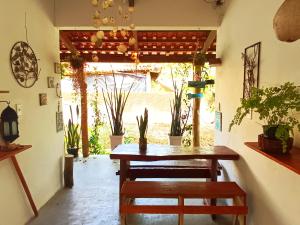 a dining room with a table and some plants at Pousada Casa de Naue - Ilha de Boipeba in Ilha de Boipeba