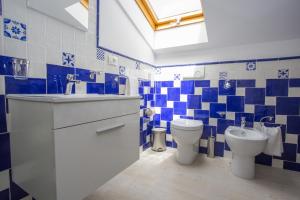 a blue and white bathroom with a toilet and a sink at B&B L'Artista in Portopalo +62 photos
