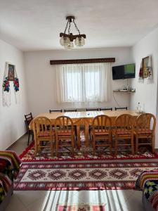 a dining room with a wooden table and chairs at Pensiunea Floare de Colt in Moisei +42 photos