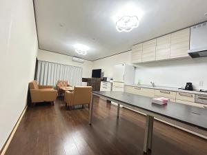 une cuisine avec une table et des chaises dans une pièce dans l'établissement Jun resort 梅, à Kujukuri