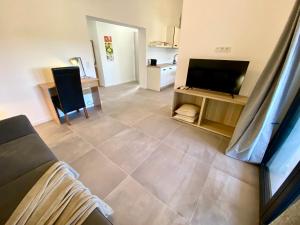 a living room with a couch and a television at Spacious, Newly Renovated, Pula Rooftop Apartment with Marina Views in Pula