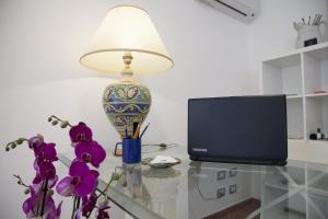 a lamp sitting on a glass table next to a tv at B&B L'Artista in Portopalo