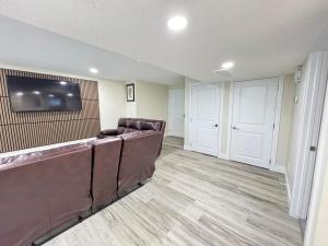 a waiting room with a couch and a flat screen tv at Annas Suites Rental in Bélanger