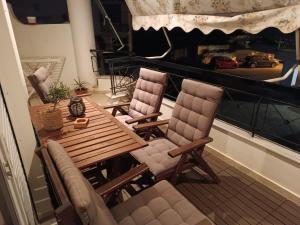 balcón con mesa de madera y 2 sillas en Agape, en Preveza