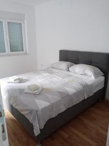 a bed in a white room with two towels on it at Apartman Teodora 1 in Trebinje