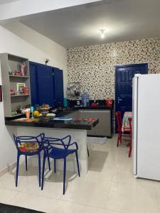 Una cocina con gabinetes azules y un refrigerador. en The Greek house, en Itapemirim