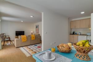 una cocina y una sala de estar con una mesa con bananas. en Maria Madalena, en Madalena do Mar