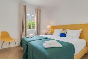 Un dormitorio con una cama con dos toallas encima. en Maria Madalena, en Madalena do Mar