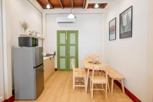 une cuisine et une salle à manger avec une table et un réfrigérateur dans l'établissement Kraft Haus, à Khlong San