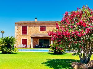 a stone house with pink flowers in the yard at Finca Reina de la isla in Felanitx