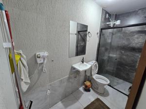 a bathroom with a shower and a toilet and a sink at Flat completo a 5 minutos apé de mercado, farmácia in Aparecida de Goiania +26 photos