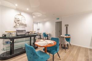 a dining room with blue chairs and a table at Hotel Riviera OPERA Cadet in Paris
