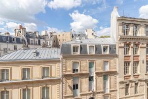 a view of the roofs of buildings in a city at Hotel Riviera OPERA Cadet in Paris