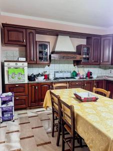 a kitchen with a table with a yellow table cloth at Villino Emma in Santadi +7 photos
