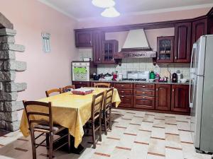a kitchen with a table with chairs and a refrigerator at Villino Emma in Santadi