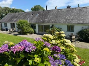 a house with flowers in front of it at Gwyllt Cottages in Dwyran
